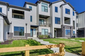 A multi-story residential building with a modern design, featuring balconies, large windows, and a well-maintained lawn. - Mountain Green Luxury Retreat By Snowbasin Resort! (Mountain Green)