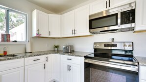 A kitchen with white cabinets, a stainless steel microwave, and an oven. - Charming Beach Haven West Home: 1 Mi to Beach! (Manahawkin)