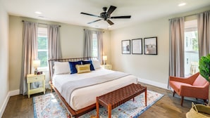 A bedroom with a bed, a ceiling fan, a nightstand, a chair, and a window with curtains. - Getaway w/ Fire Pit: 3 Mi to River Arts District! (Asheville)