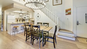 A spacious kitchen with a central island, a dining area with a wooden table and chairs, and a staircase leading to an upper level. - Brian Head Rental w/ Community Hot Tub & Sauna! (Brian Head)