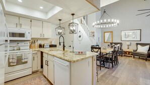 A modern kitchen with white cabinetry, a built-in microwave, and a granite countertop. - Brian Head Rental w/ Community Hot Tub & Sauna! (Brian Head)