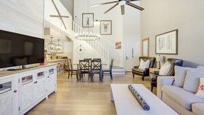 A spacious living area with a large flat-screen TV, a dining table with chairs, a sofa, and a ceiling fan. - Brian Head Rental w/ Community Hot Tub & Sauna! (Brian Head)