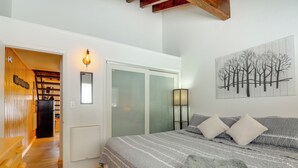 Une chambre à coucher avec un lit, une armoire et un tableau accroché au mur.