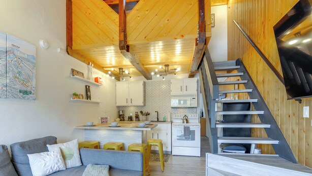 Une cuisine moderne avec des meubles blancs, un îlot central et une cuisinière.