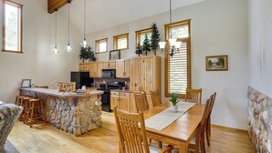 A spacious kitchen with wooden cabinets, a stone island, and a dining area with wooden chairs and a table. - Spacious Beaver Getaway Near Eagle Point Resort! (Beaver)