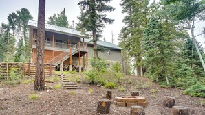 A cabin with a deck, surrounded by trees and a fire pit area. - Spacious Beaver Getaway Near Eagle Point Resort! (Beaver)