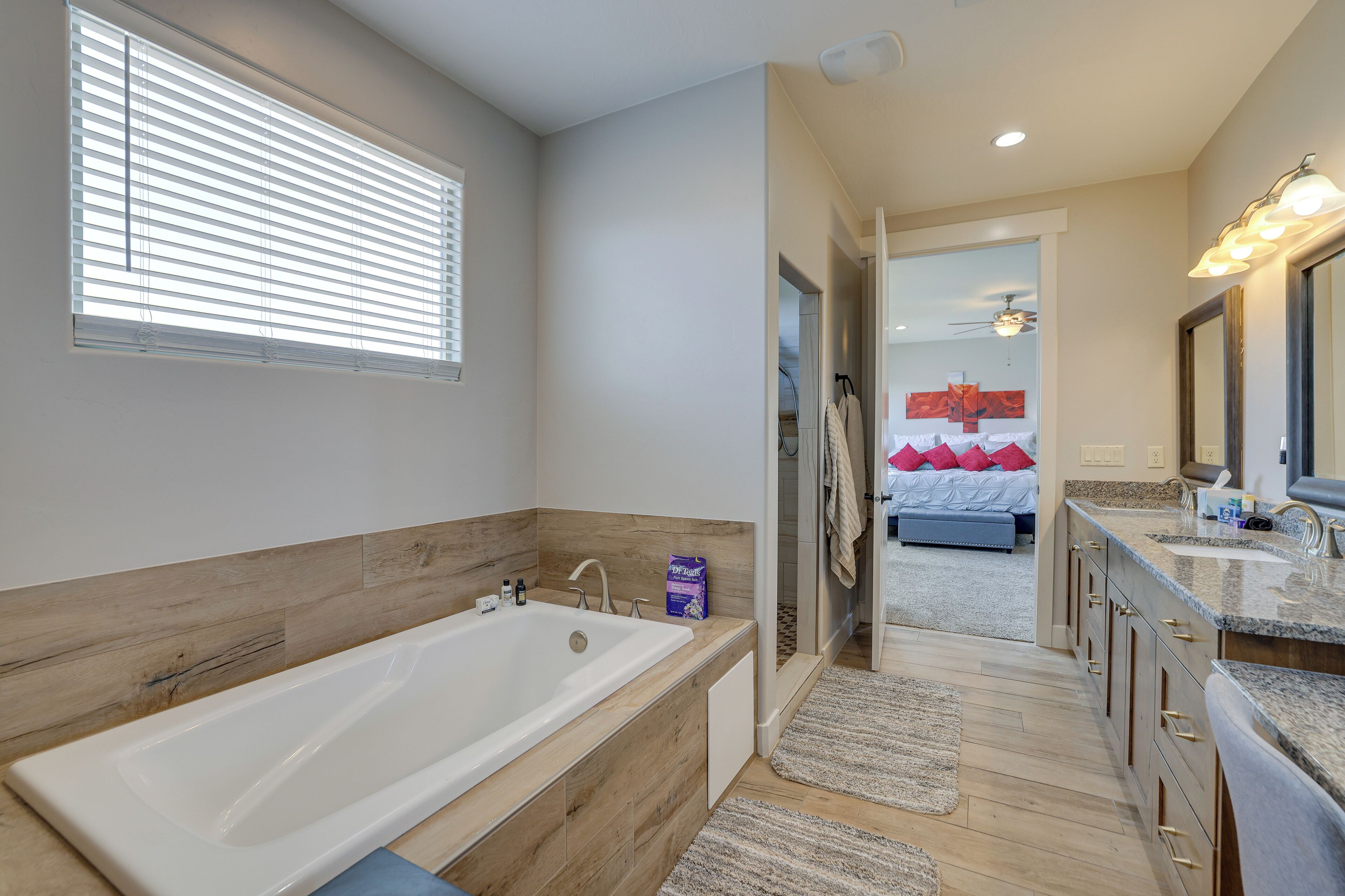 Een moderne badkamer met een groot bad, houten lambrisering en een inloopdouche.