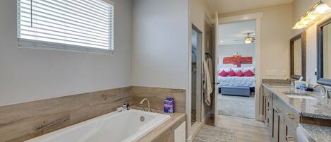 Een moderne badkamer met een groot bad, houten lambrisering en een inloopdouche.