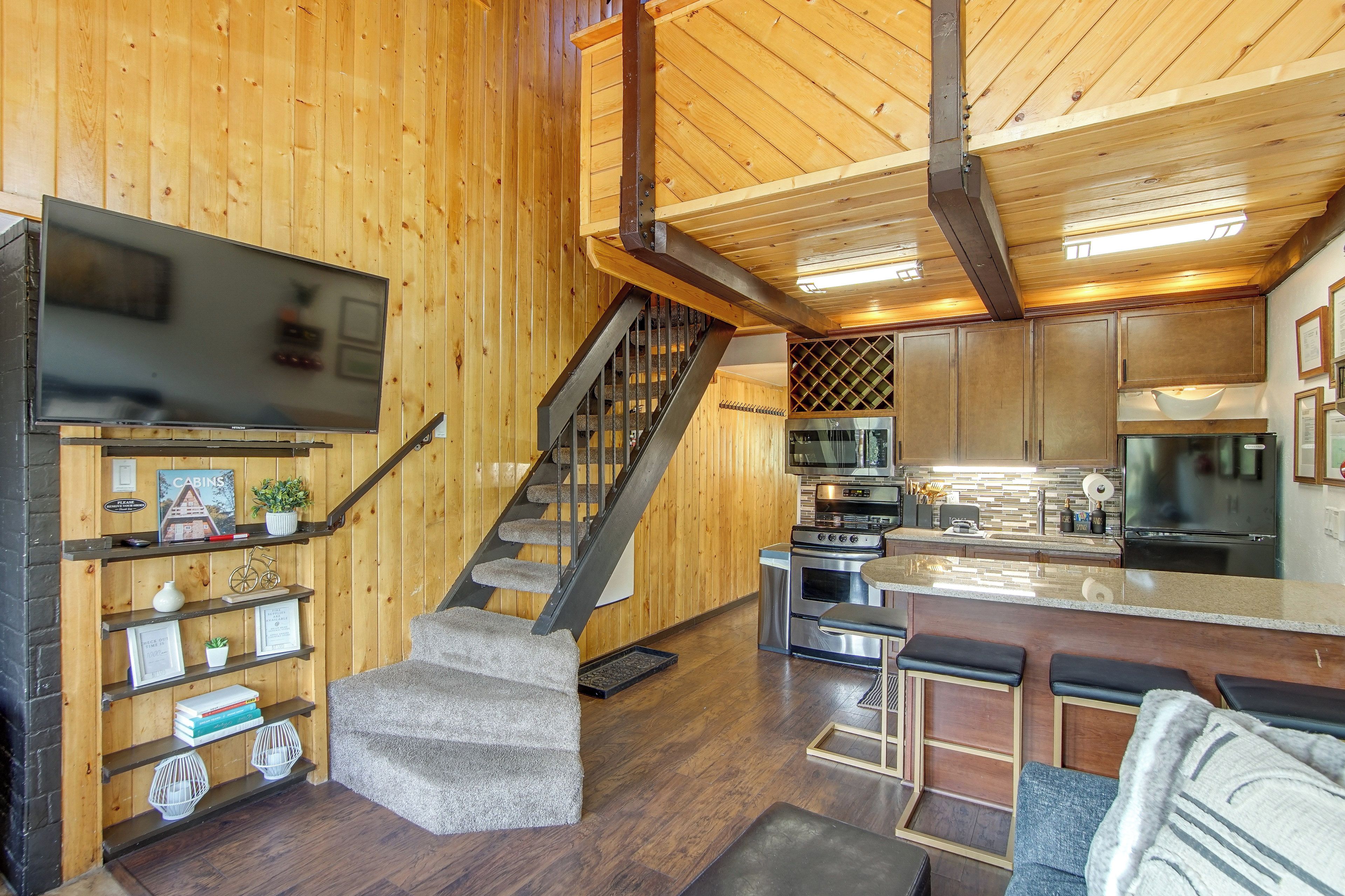 A wooden interior with a staircase, kitchen, and living area.