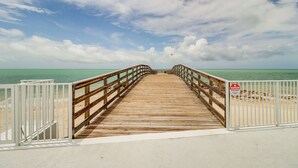 A wooden pier leading to a beach with a 'No Trespassing' sign. - Ocean-view Key Colony Beach Condo w/ Pool Access! (Key Colony Beach)