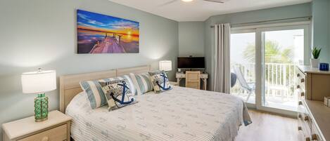 A bedroom with a bed, nightstands, a TV, a desk, and a balcony with a view.