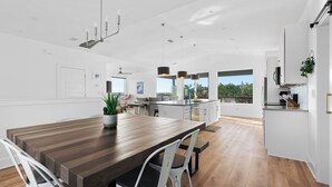 A modern kitchen with a large island, white cabinetry, and a view of the outdoors. - Lago Vista Home w/ Game Room & Outdoor Tub! (Leander)