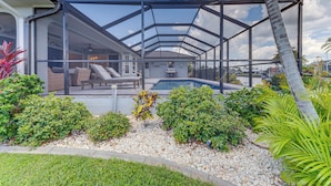 Uma casa com área externa coberta, piscina e diversas plantas.