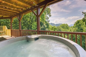 A hot tub under a wooden deck with a view of a forest and mountains. - Mtn-view Escape w/ Hot Tub, 9 Mi to Skiing! (Maggie Valley)