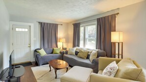 A living room with two sofas, a coffee table, a TV, and a lamp.