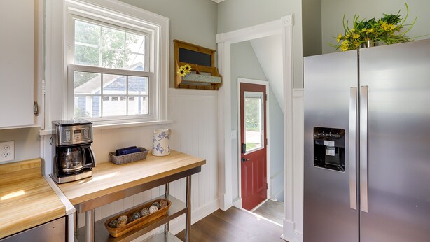 Una cocina con un refrigerador de acero inoxidable, una cafetera y un ventanal con vistas al exterior.