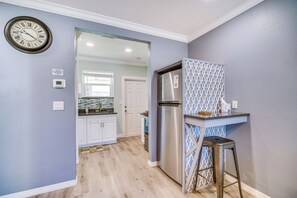 A kitchen with a stainless steel refrigerator, a clock on the wall, and a patterned wall panel. - Cozy Melbourne Hideaway Near Beaches, Downtown! (Melbourne)