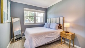 A bedroom with a bed, bedside table, lamp, and a window. - Cozy Melbourne Hideaway Near Beaches, Downtown! (Melbourne)
