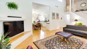 A spacious living area with a flat-screen TV, a sofa, a patterned rug, and a staircase leading to an upper level. - Granger Gathering Place, 4 Mi to Notre Dame (Granger)