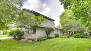 A two-story house with a well-maintained lawn and various shrubs and trees. - Granger Gathering Place, 4 Mi to Notre Dame (Granger)