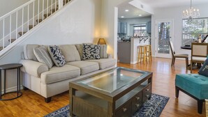 Un salon spacieux comprenant un canapé, une table basse et un escalier menant à l’étage supérieur.