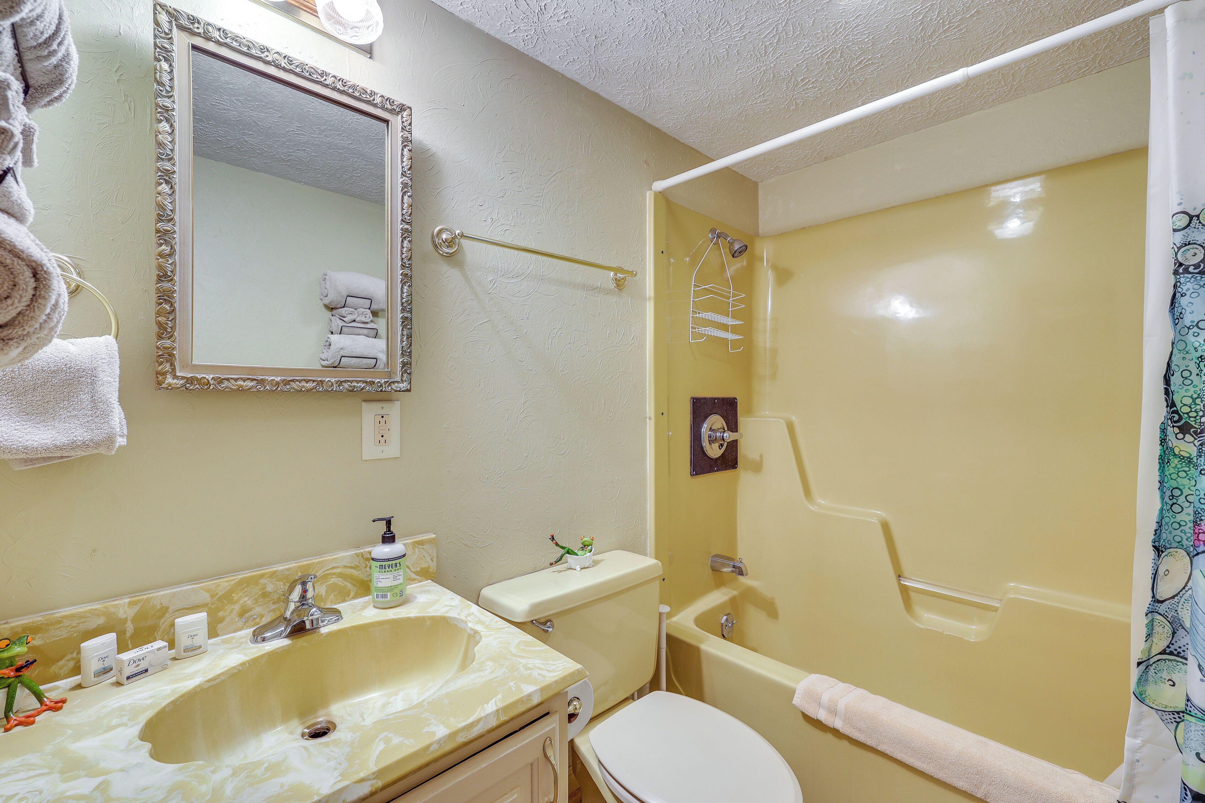 A bathroom with a sink, toilet, and shower.