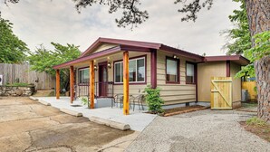 A single-story house with a covered porch, stone steps, and a gravel driveway. - Eureka Springs Rental - Walk to Downtown! (Eureka Springs)