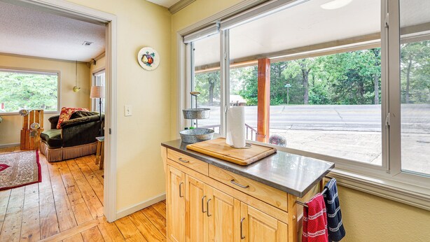 A kitchen with wooden cabinets, a wooden countertop, and a large window with a view of the outdoors. - Eureka Springs Rental - Walk to Downtown! (Eureka Springs)