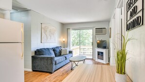A modern living room with a sofa, a small round table, and a potted plant. - Kimberling City Cabin w/ Boat Slip, Deck & Pool (Kimberling City)