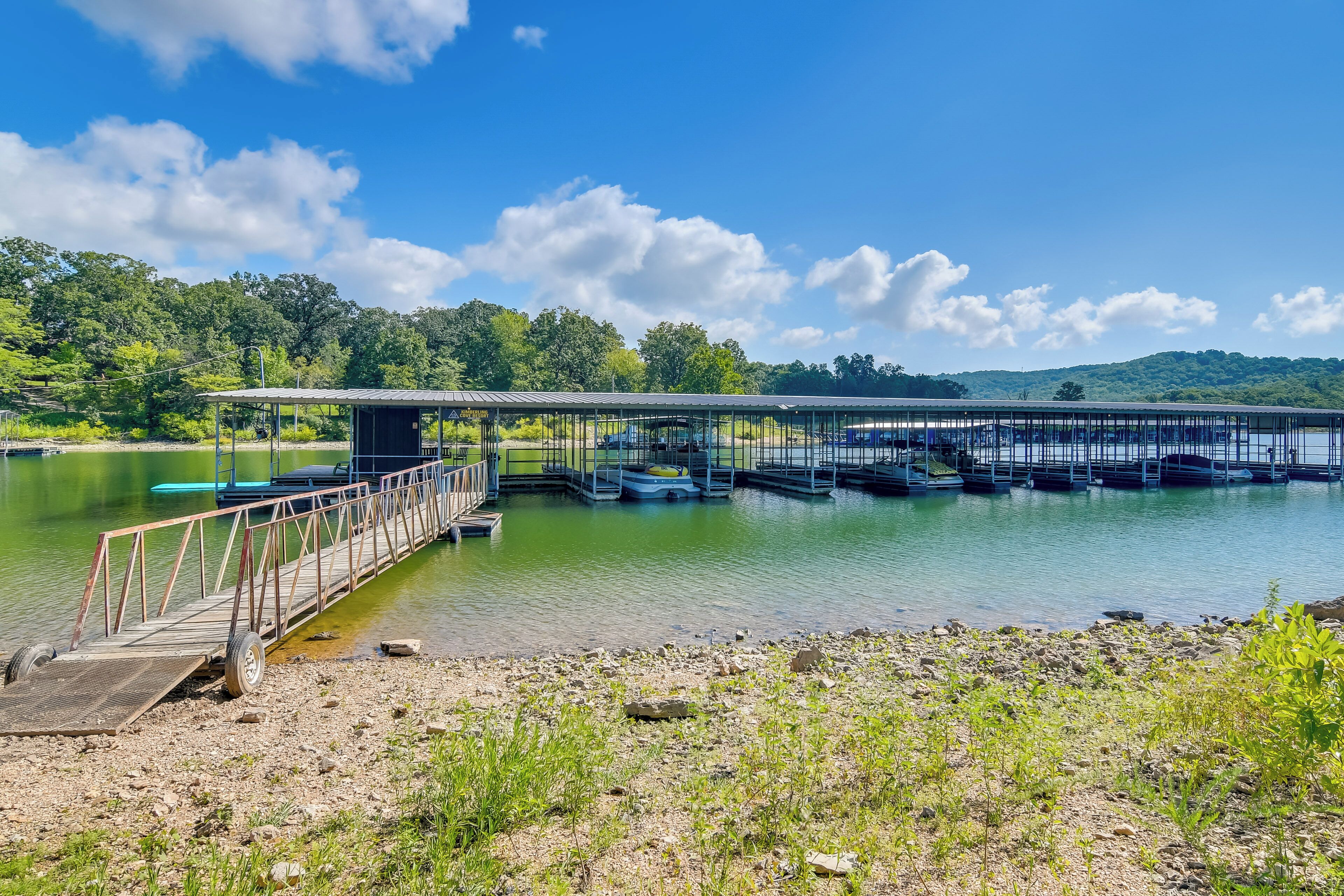 Une jetée s’avançant dans un lac paisible, avec un pont métallique qui la surplombe.