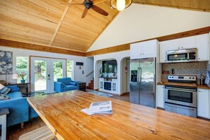 A spacious kitchen with wooden cabinets, a large island, and stainless steel appliances.