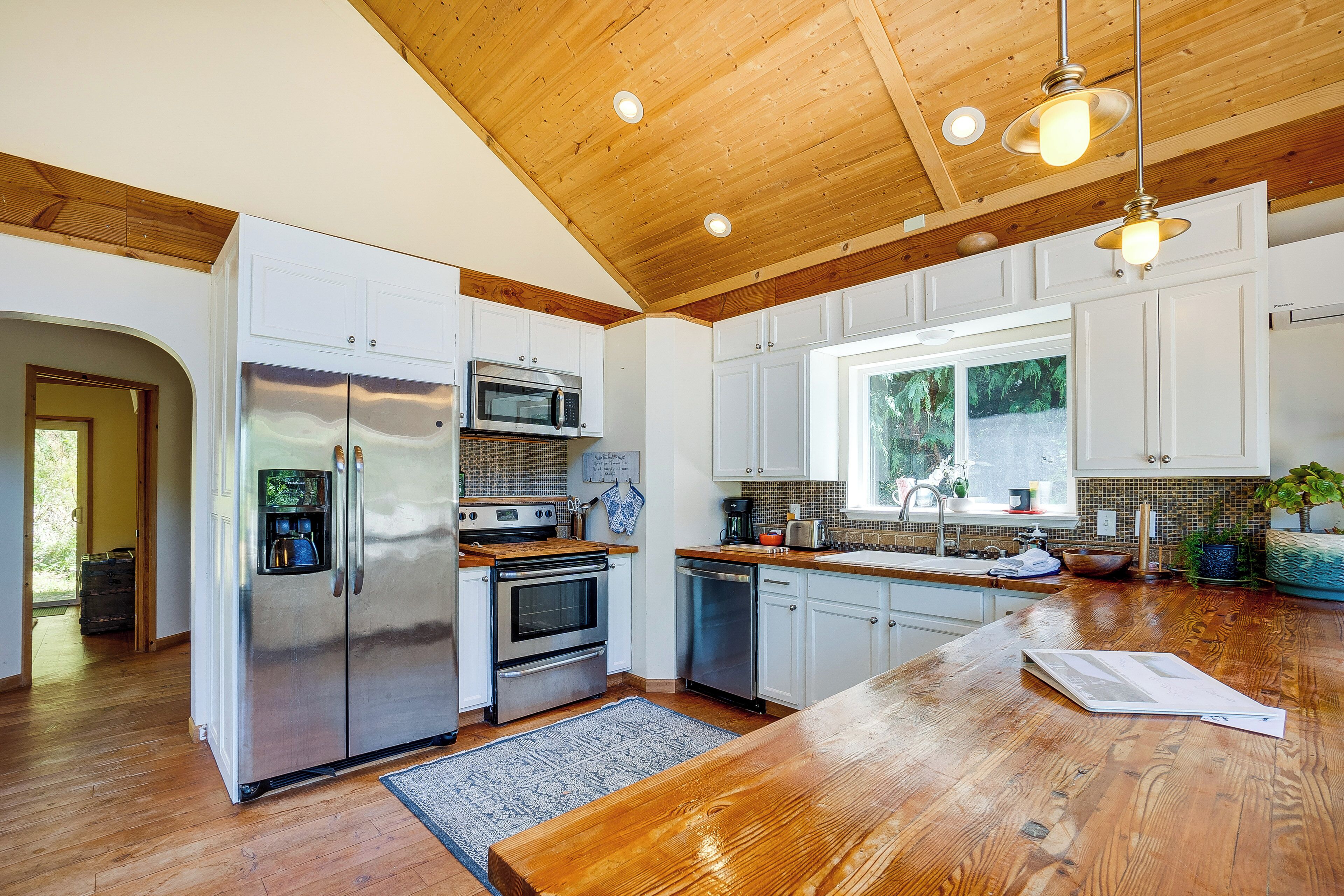 A modern kitchen with stainless steel appliances, wooden countertops, and a large island.