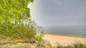 A beach with sand dunes and greenery. - Holland Home w/ Fire Pit: Walk to Lake Michigan! (Holland)