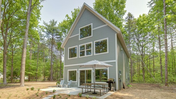 A two-story house with a patio area, large windows, and a covered seating area. - Holland Home w/ Fire Pit: Walk to Lake Michigan! (Holland)