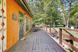 A wooden cabin with a deck, a table, and chairs. - Pools & Ski Access: Lackawaxen Cottage w/ Deck! (Lackawaxen)