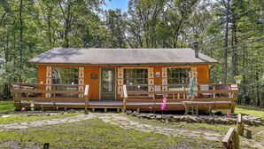 A cabin with a porch, a door, and a window. - Pools & Ski Access: Lackawaxen Cottage w/ Deck! (Lackawaxen)