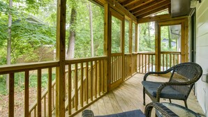 A wooden deck with a wicker chair and a rug. - Charming Cary Home ~ 10 Mi to Downtown Raleigh! (Cary)