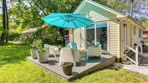 A small house with a deck, outdoor seating, and a large umbrella. - All-season Vernon Township Lake House Retreat! (Highland Lakes)