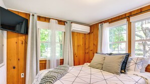 A bedroom with a bed, a TV, and an air conditioning unit. - All-season Vernon Township Lake House Retreat! (Highland Lakes)