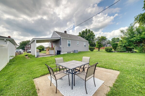 A backyard with a patio table and chairs, a covered patio area, and a lawn. - Deck & Patio: Inviting Abode in Natrona Heights! (Natrona Heights)