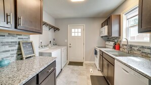 A modern kitchen with granite countertops, stainless steel appliances, and dark wooden cabinets.