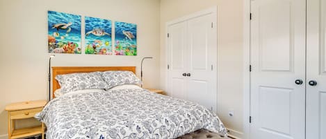 Una camera da letto con un letto, una panca, un comodino e due porte.
