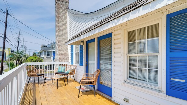 A wooden deck with wicker chairs and a table, white railings, and blue shutters on a house. - Carolina Beach Home w/ Private Deck: Walk to Shore (Carolina Beach)