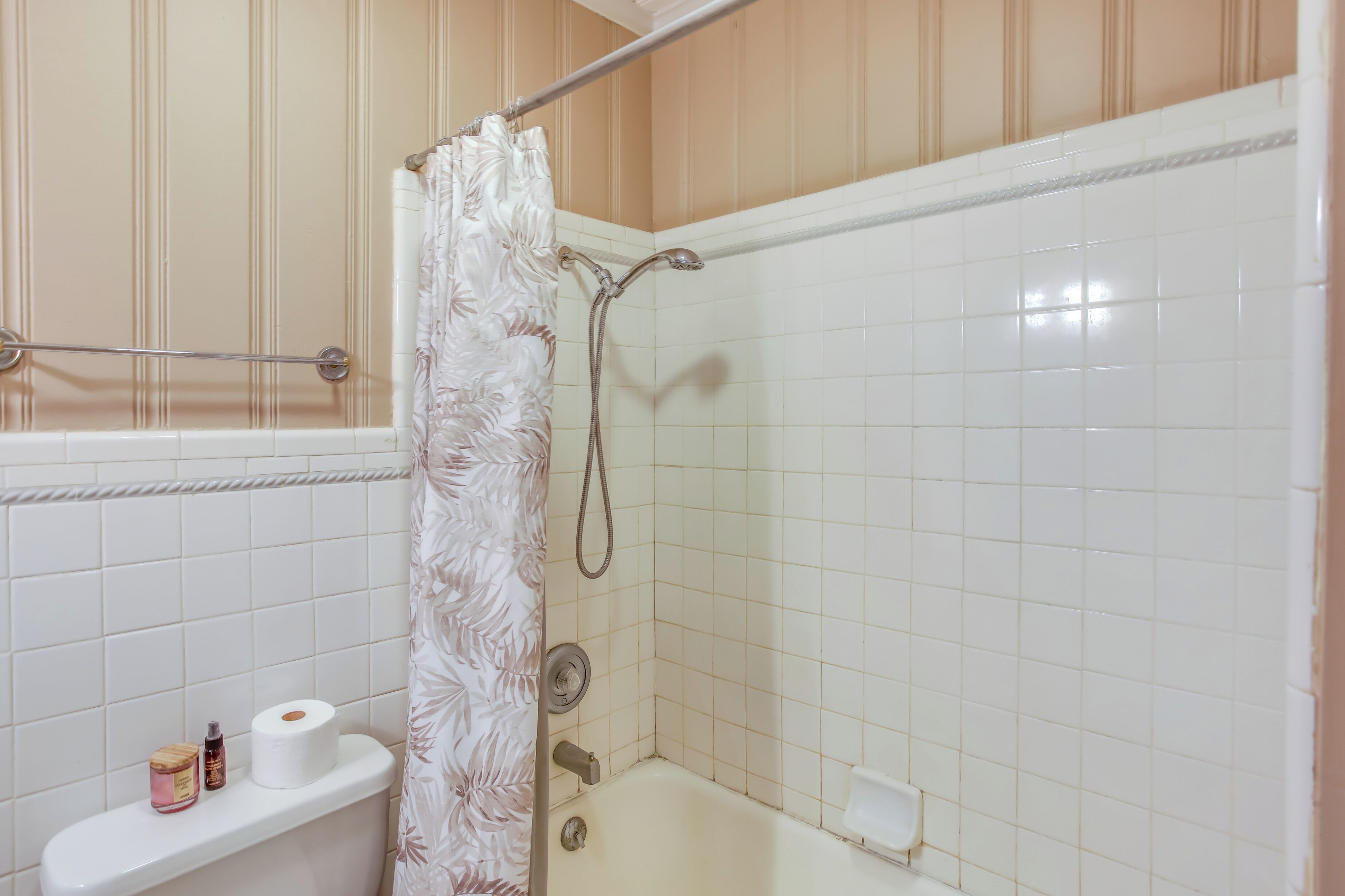 Une salle de bain équipée d’une douche, de toilettes et d’une étagère où sont rangés les produits de toilette.