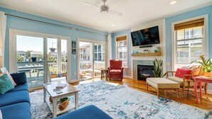 Un salón espacioso con un sofá azul, un sillón rojo y una chimenea.
