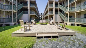 Een meerlaags gebouw met buiten zitplaatsen op een houten terras.