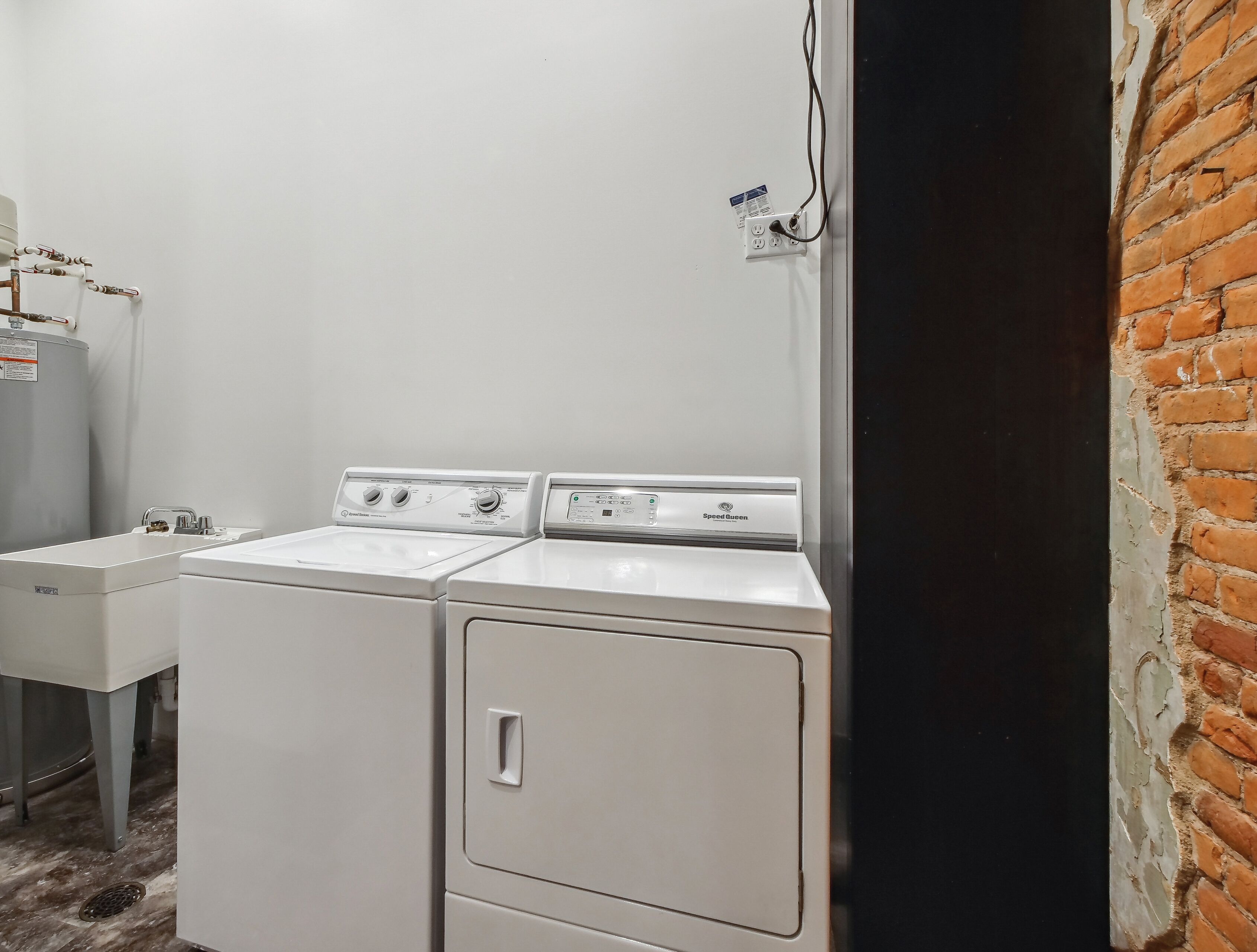 A laundry area with two Speed Queen washers and a water heater.