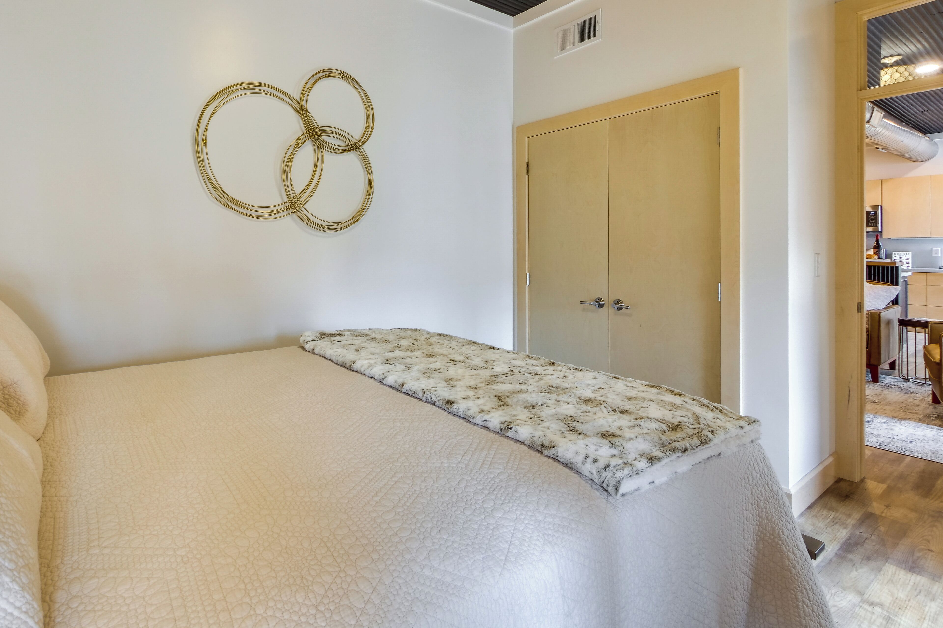 Una camera da letto con un letto, un armadio e un decoro circolare a parete.