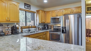 A kitchen with wooden cabinets, stainless steel appliances, and a granite countertop. - 2 Mi to Show Low Lake: Scenic Cabin w/ Balcony (Show Low)