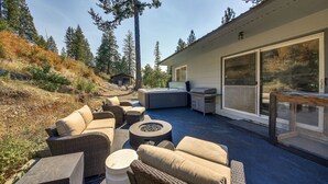Une terrasse extérieure aménagée avec des meubles en osier, un foyer et un espace barbecue.